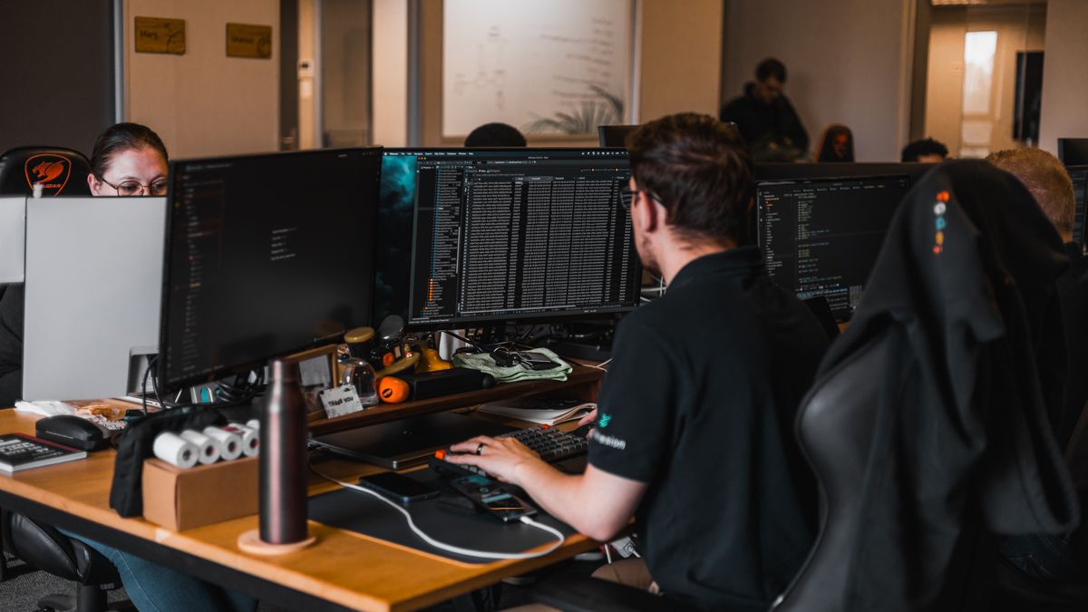 A Codehesion developer at work at a multi-screen desk